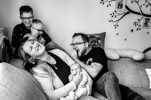 Glückliche Familie mit zwei Kindern und einem Neugeborenen, betreut von Hebamme Romy Leuteritz während der Schwangerschaft und Nachsorge in Zwickau
